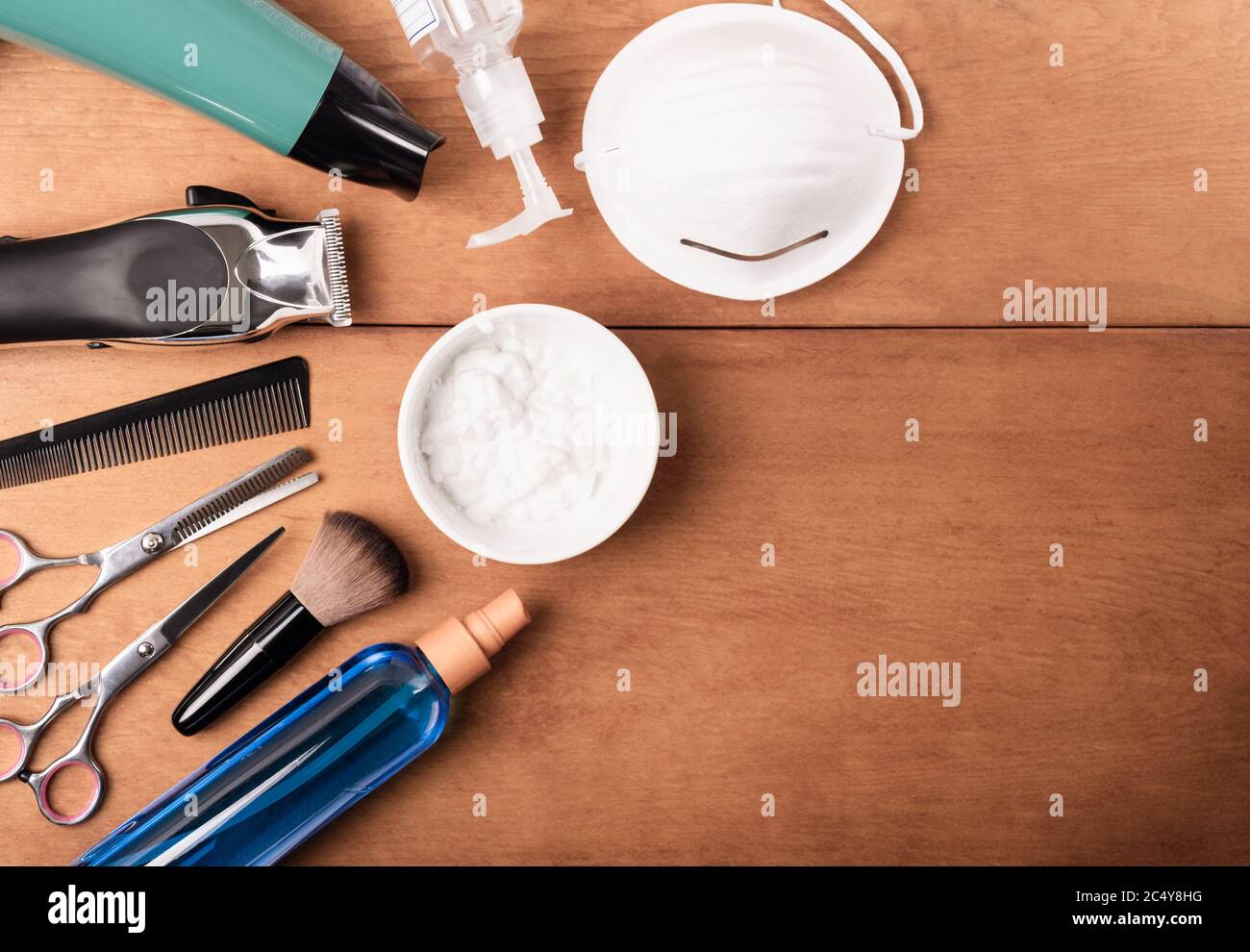 Friseursalon und Friseursalon, nach Quarantäne; auf Holzhintergrund mit Gesichtsmaske, Händedesinfektionsmittel, Barber Clippers, Haarbläser, Schere. Kopierraum. Stockfoto