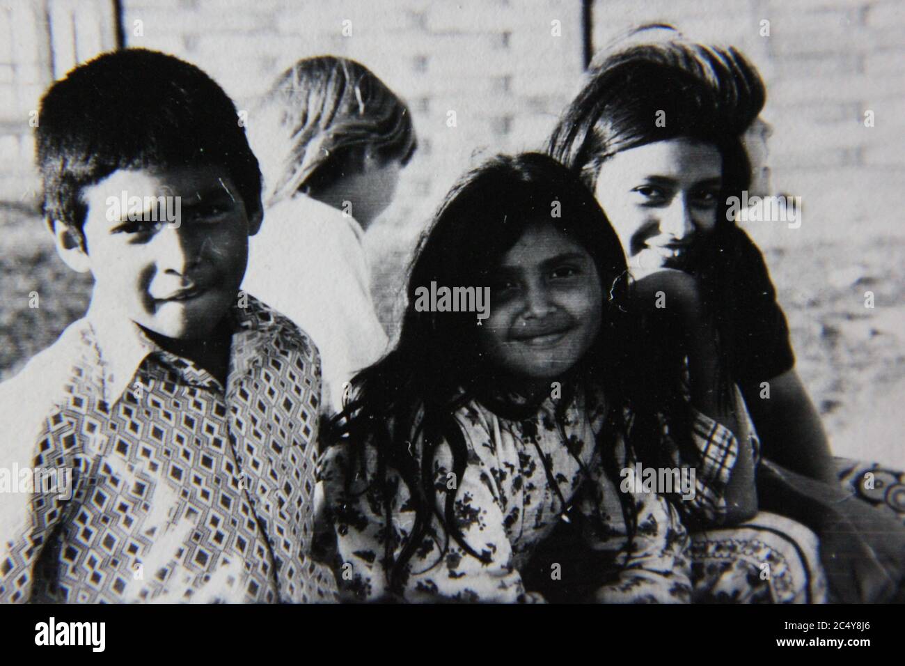 Feine 70er Jahre Vintage Schwarz-Weiß-Fotografie einer Gruppe von hispanischen Kindern, die miteinander rumhängen. Stockfoto