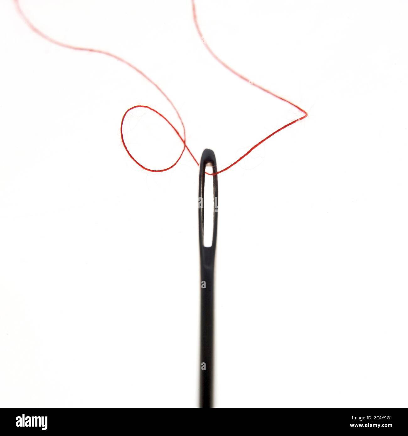 Faden durch Nadelöhr Stockfoto