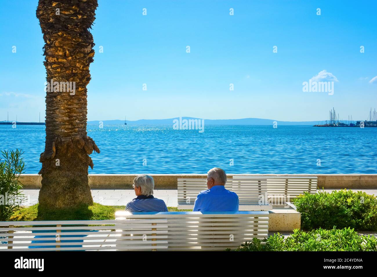 Ein reifes Paar entspannen auf einer Bank an der Riva Uferpromenade, an der dalmatinischen Küste von Split, Kroatien Stockfoto