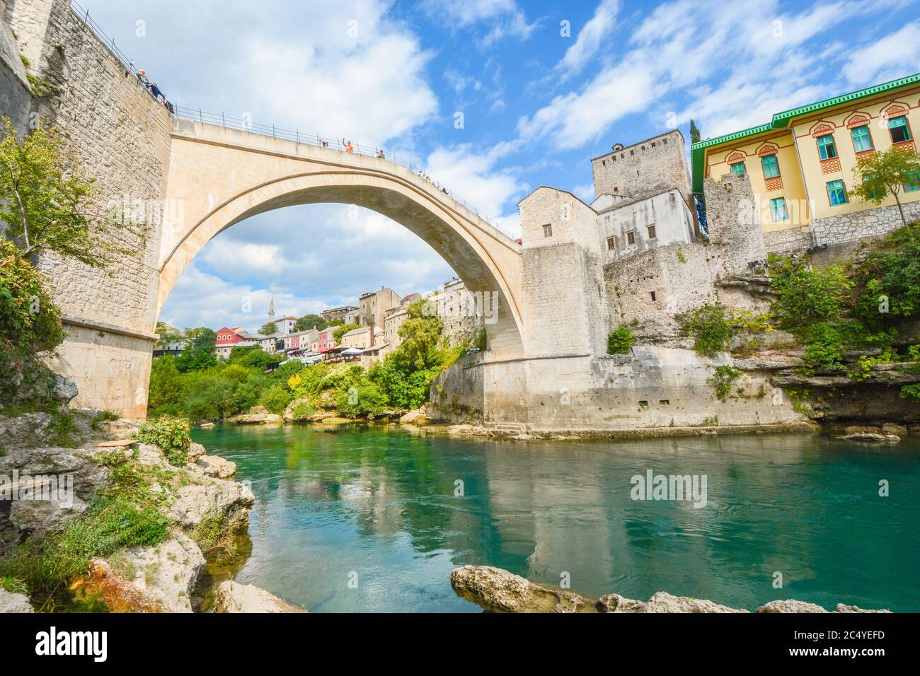 Das smaragdgrüne Wasser des Flusses Neretva fließt unter der Mostar-Brücke in der antiken Stadt Mostar, Bosnien und Herzegowina Stockfoto