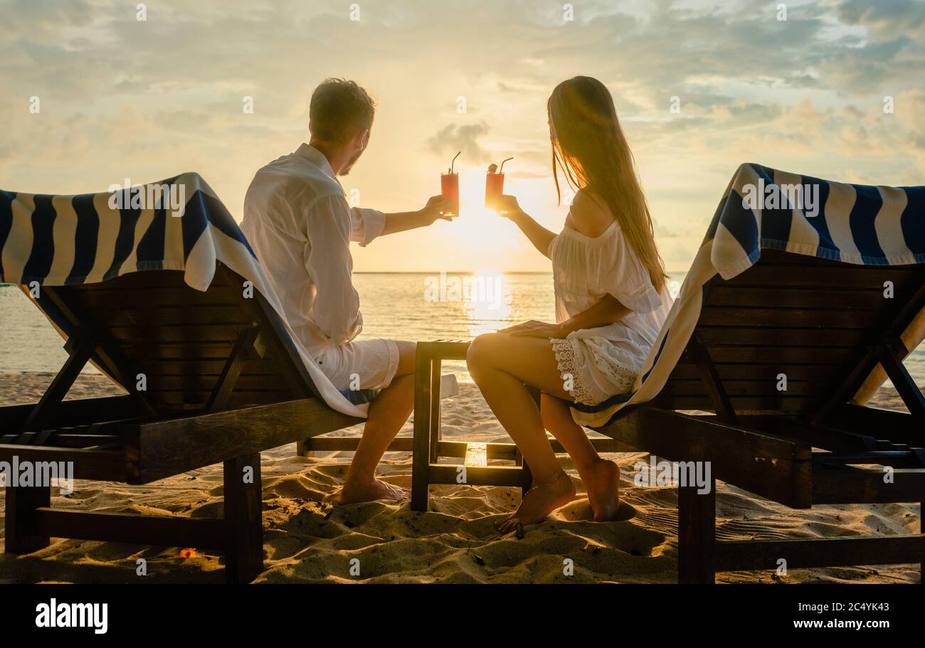Paar trinken Cocktails am Strand während des Urlaubs oder Flitterwochen in den Tropen Stockfoto