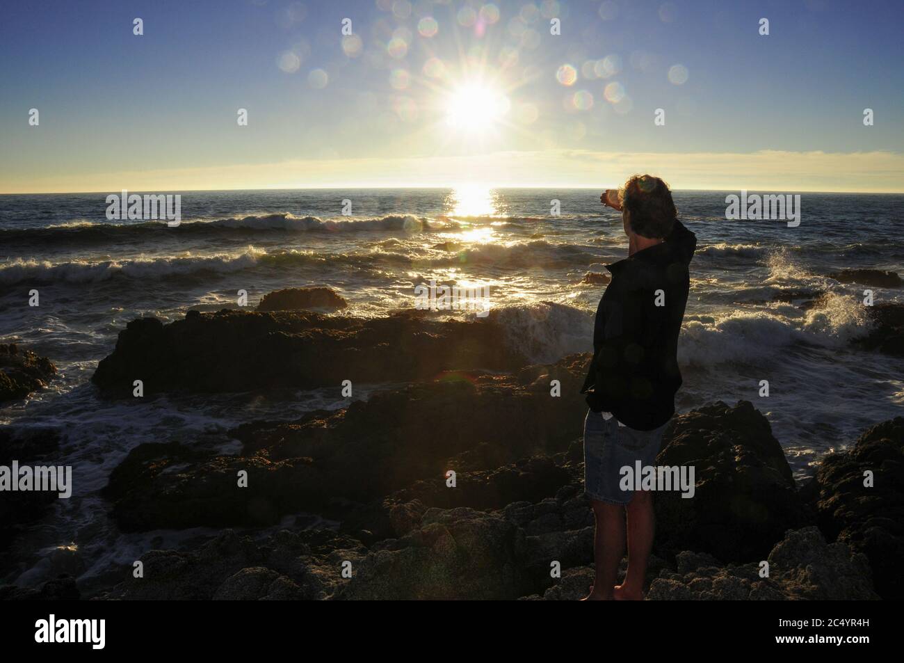 Mann in Silhouette am Strand beim Blick auf den Sonnenuntergang. Konzept Foto Blick auf das Meer, ferne Küste, Reisen, Inspiration, Phantasie. Modellversion. Stockfoto