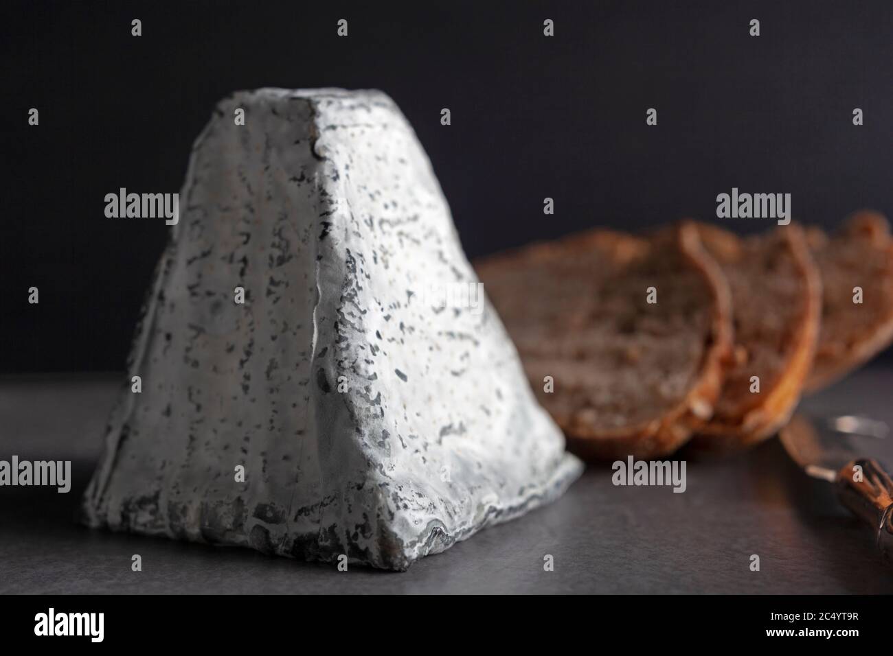 Eine mit Asche überzogene Ziegenkäse-Pyramide mit Sauerteig-Toast Stockfoto