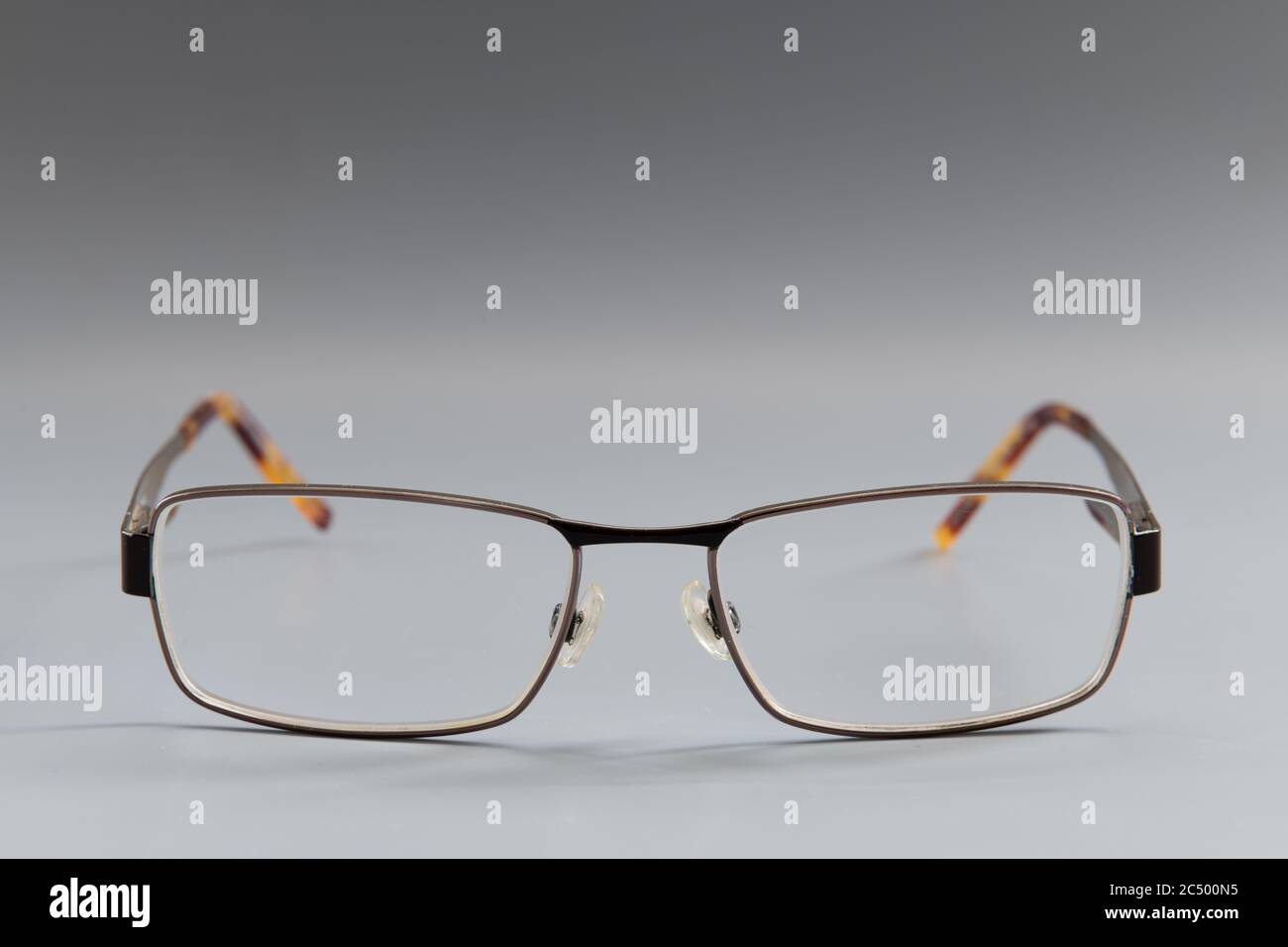 Ein Paar verschreibungspflichtige Augenbrillen mit Metallrahmen, isoliert mit einem grauen Hintergrund. Stockfoto