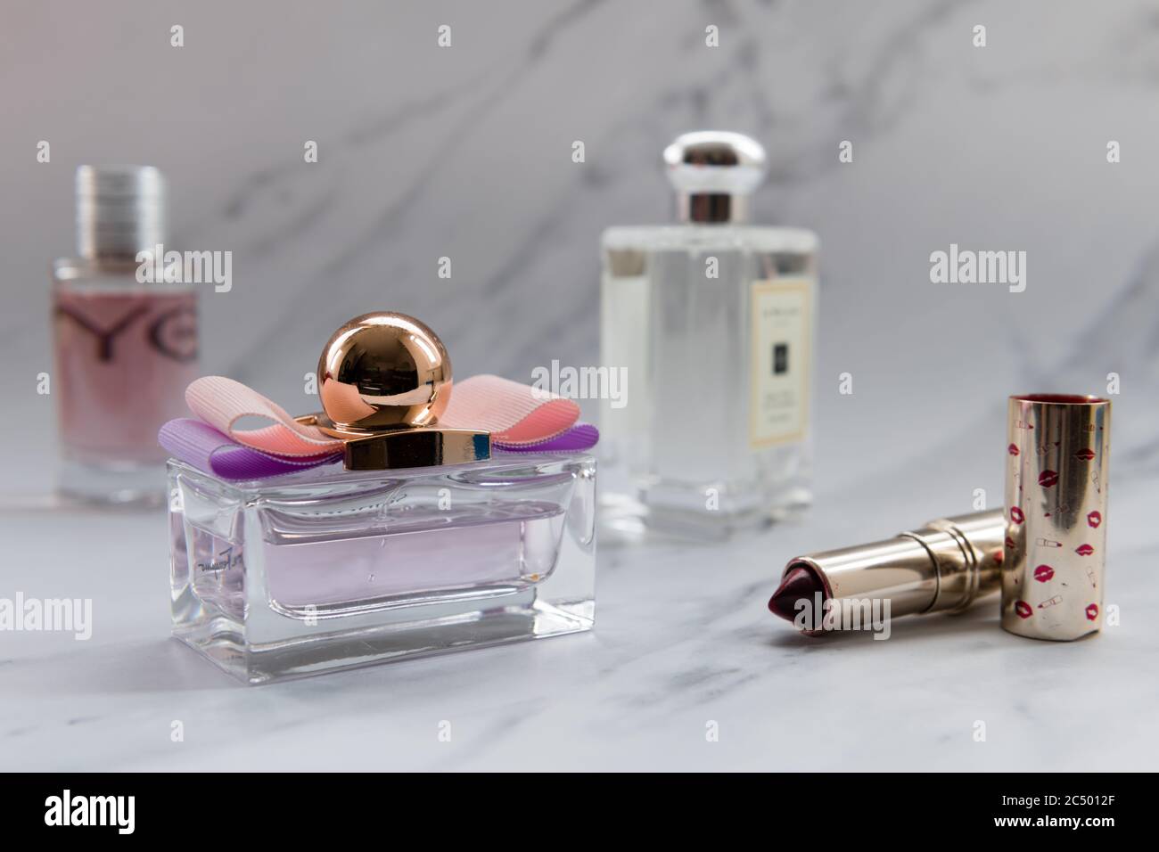 Parfüms und Lippenstift isoliert mit einem grauen Marmor Hintergrund. Stockfoto
