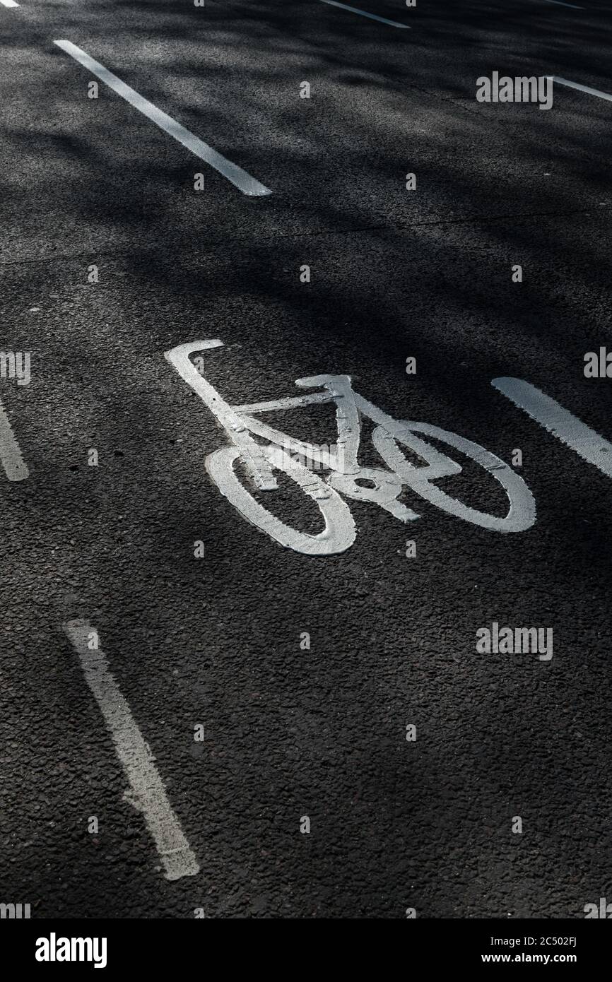Das Symbol eines Fahrrads mit Fahrbahnmarkierungen auf einer Straße, die darauf hinweist, dass es eine Fahrradspur ist. Stockfoto