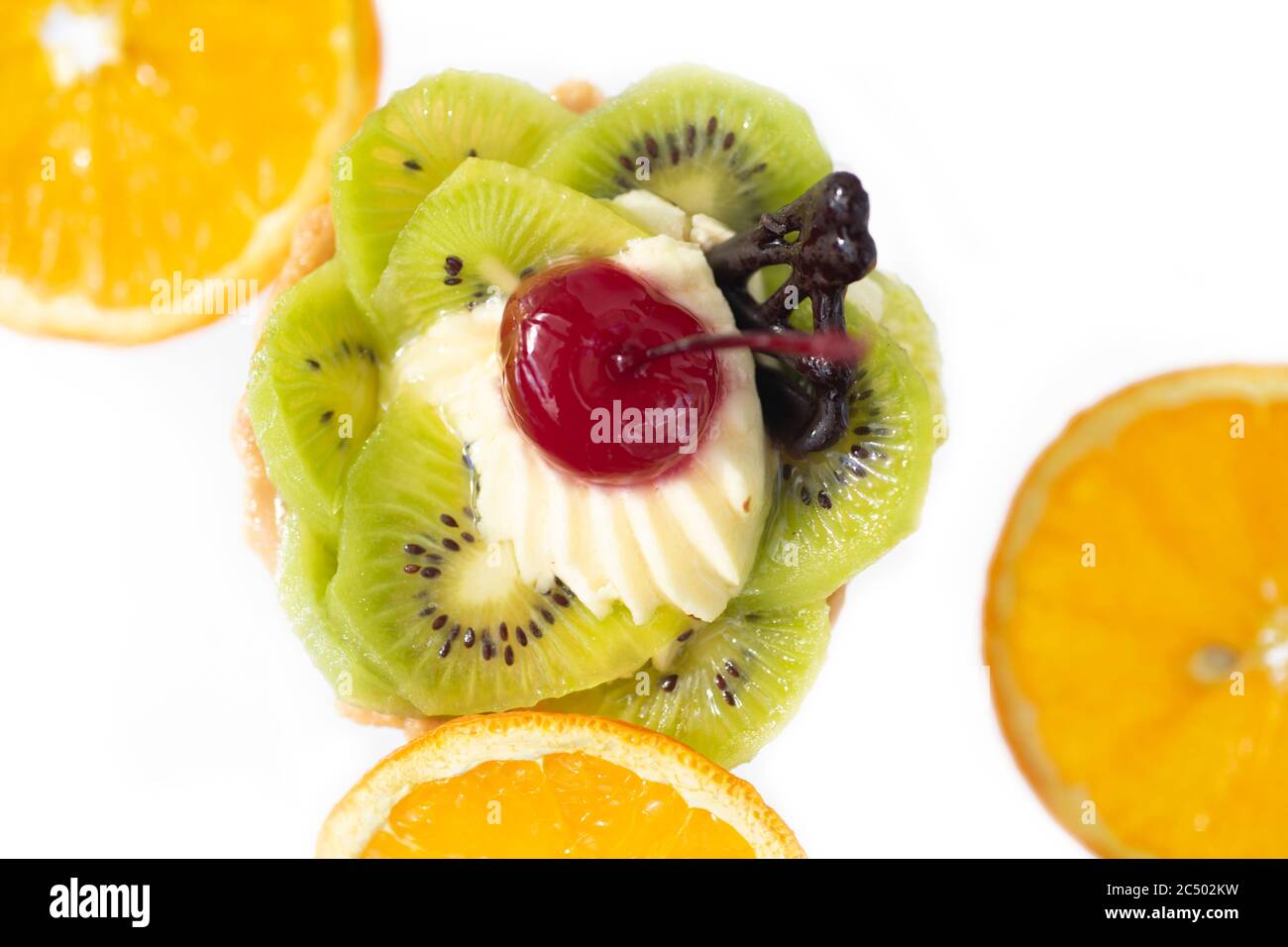 Kuchen mit Kiwi Kirschen und Pudding, in der Nähe Scheiben orange. Weißer Hintergrund Stockfoto