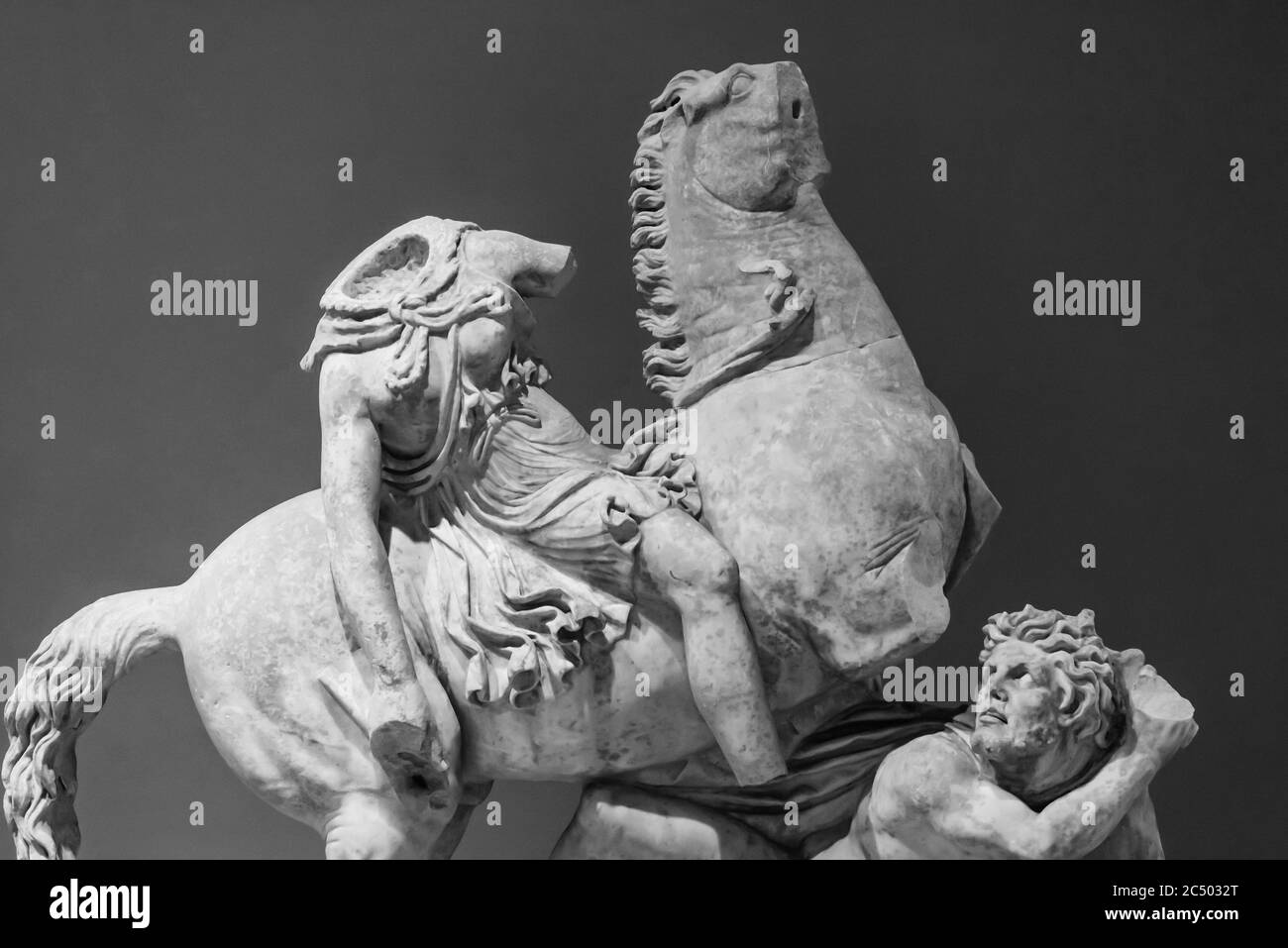 Schwarz-Weiß-Foto von alten römischen Statuen in Ruinen Zeigt einen kopflosen Soldaten, der auf einem Pferd gegen einen Mann reitet Auf dem Boden Stockfoto