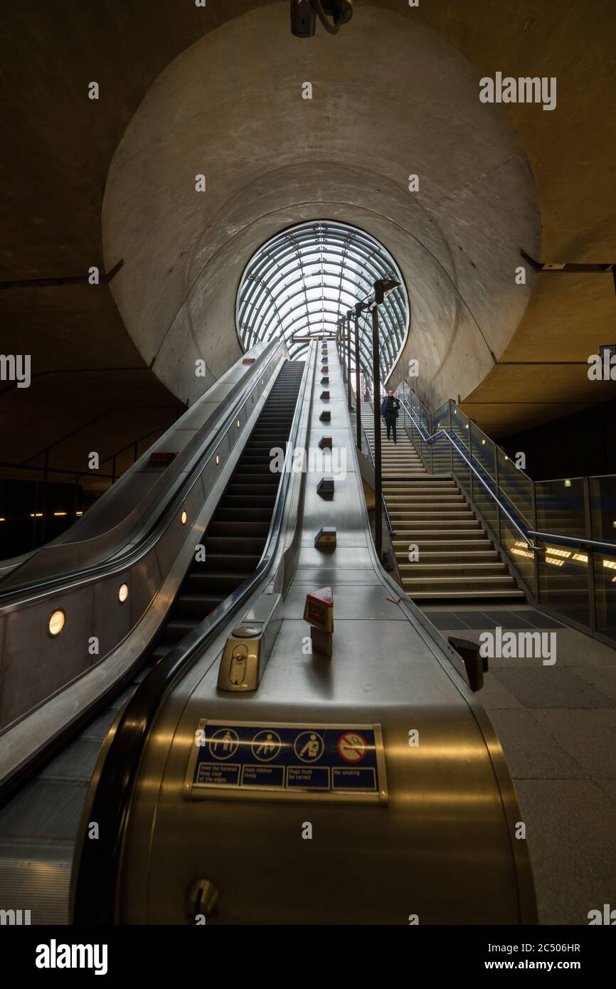 Die Rolltreppe und die Treppe der Canary Wharf U-Bahnstation, die zu einer der Eingangshallen führt. Stockfoto