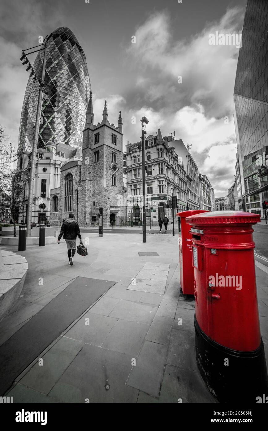 Rote Royal Briefkästen auf der Straße der City of London mit Blick auf das Gherkin oder 30 St. Mary AX Gebäude. Stockfoto