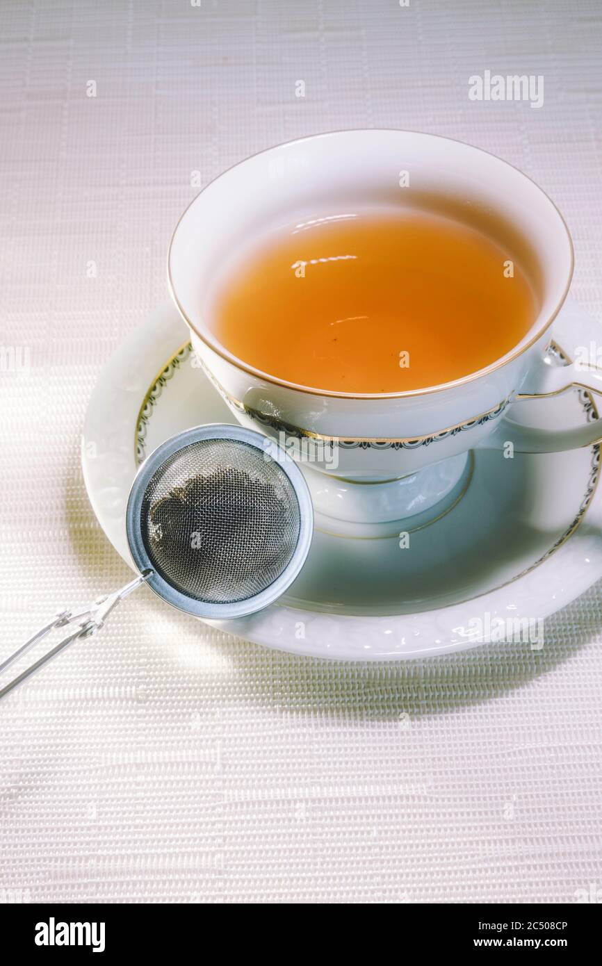 China Tasse und Untertasse mit Mesh Tee-Infuser Stockfoto