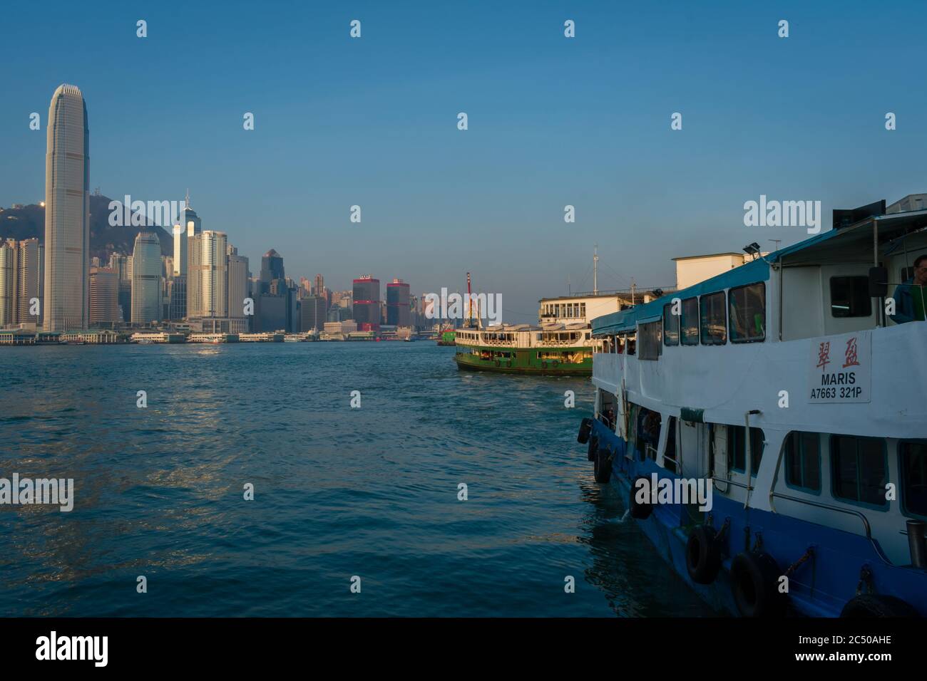 Die Star Ferry in Kowloon, Tsim Sha Tsui mit Blick auf die Wolkenkratzer auf der Insel Hongkong. Stockfoto