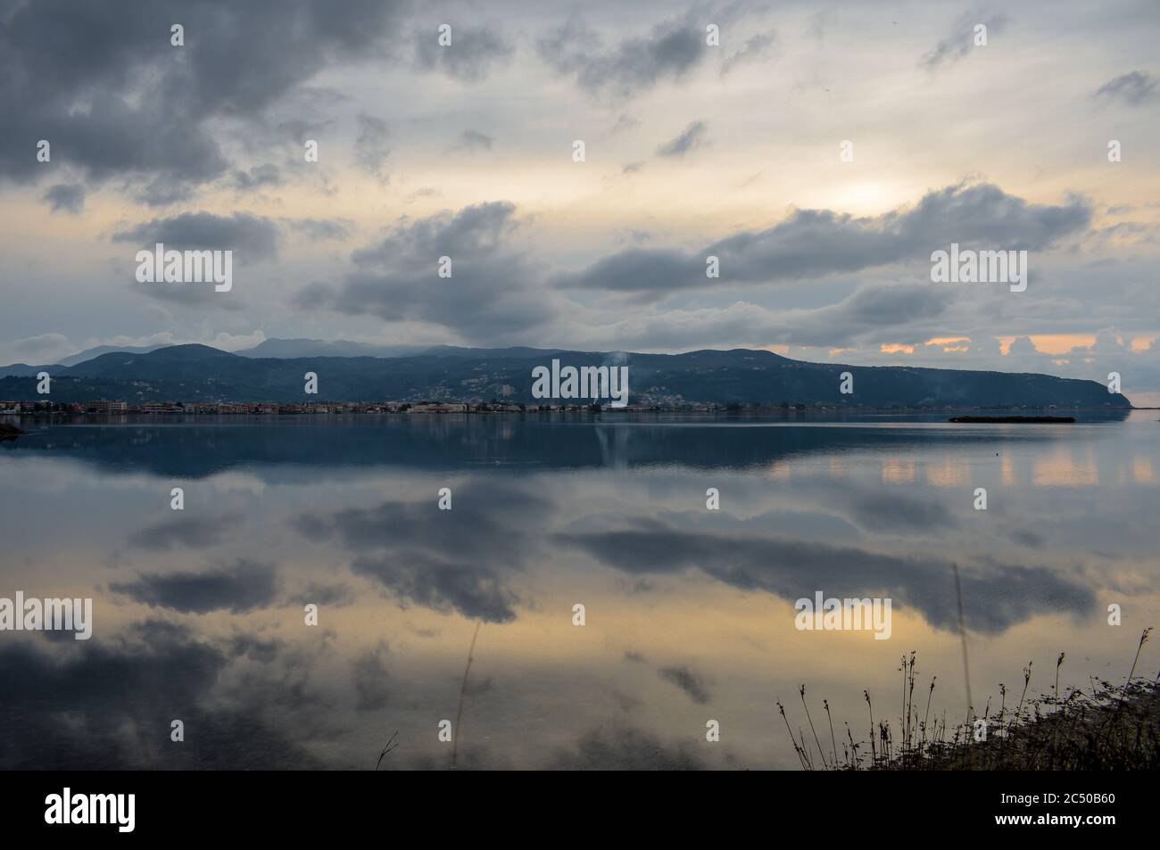 Morgenspiegelung der Insel Lefkada mit Wolken auf stillem Meerwasser. Stockfoto