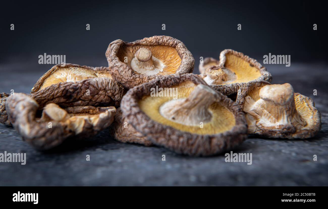 Ein Haufen getrockneter Shiitake-Pilze mit dunklem Hintergrund. Stockfoto