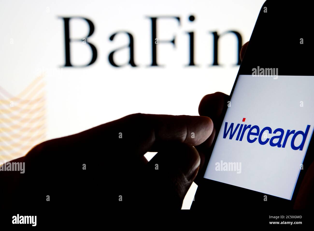 Wirecard-Logo auf dem Smartphone und BaFin-Logo auf dem unscharfen Hintergrundbildschirm. Stockfoto
