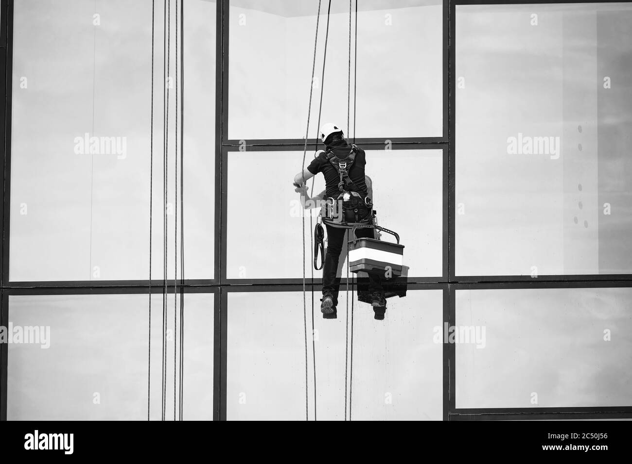 Fensterputzer bei der Arbeit. Fensterreiniger im Aufhängungssystem. Industrieller Bergsport. Stockfoto