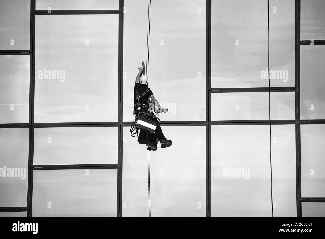 Fensterputzer bei der Arbeit. Fensterreiniger im Aufhängungssystem. Industrieller Bergsport. Stockfoto