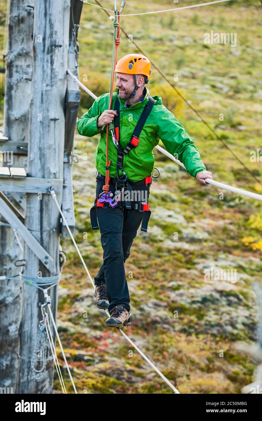 Mann balanciert auf Hochseil-Hindernisparcours in Island Stockfoto