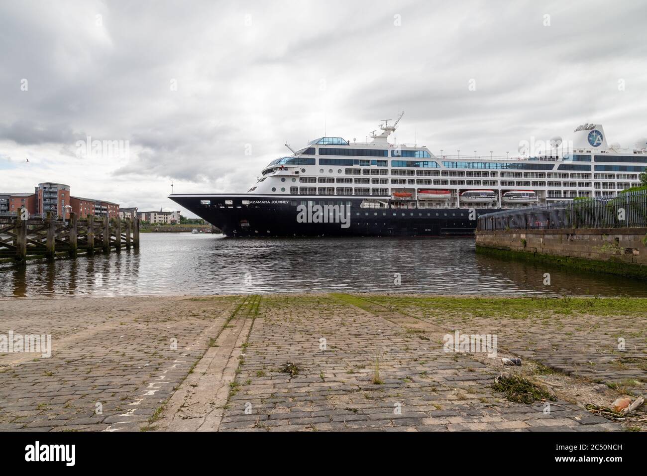 Das Kreuzfahrtschiff Azamara Journey stellt den Yoker Ferry Slipway in den Schatten, als es den Fluss Clyde hinauf zu den Docks von King George V fährt Stockfoto
