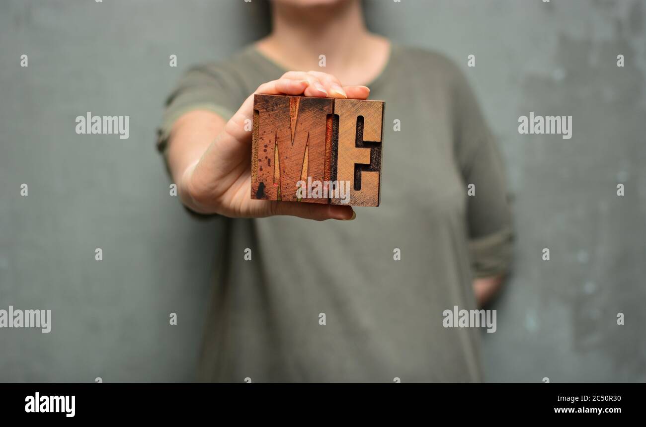 Frau mit dem Wort "ich" aus typografischen Holzbuchstaben. Emanzipation, Persönlichkeit, Menschenrechte, LGBT, Feminismus, Selbstvertrauen Konzept Stockfoto