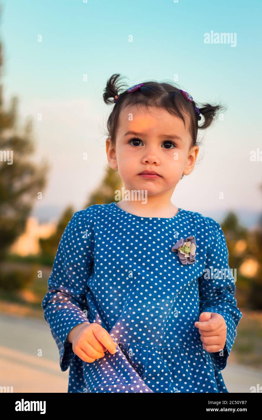 Ein nettes kleines Mädchen in einem stilvollen Kleid mit Punktmuster Stockfoto