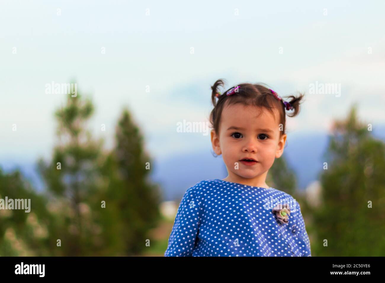 Ein nettes kleines Mädchen in einem stilvollen Kleid mit Punktmuster Stockfoto