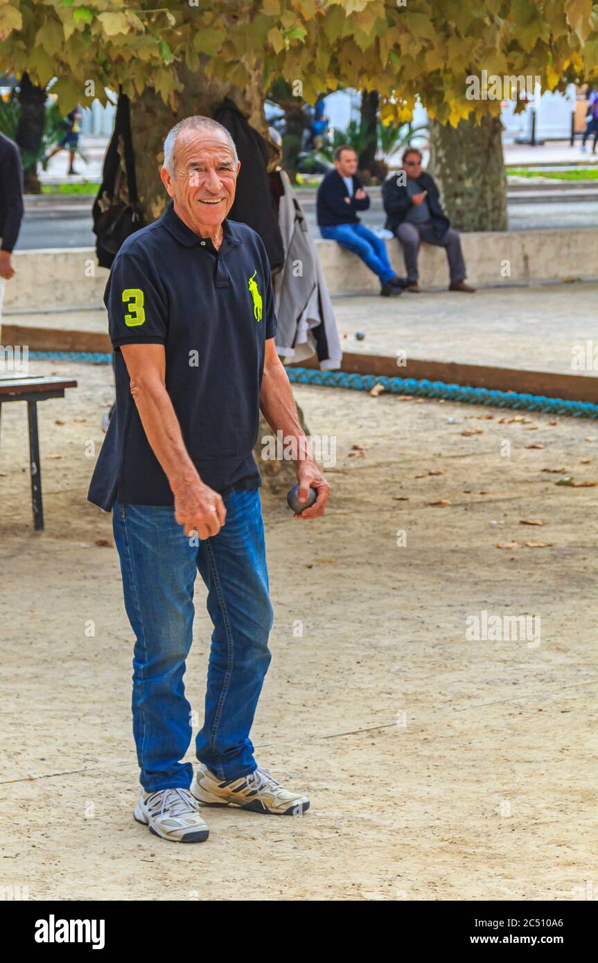 Cannes, Frankreich - 17. Oktober 2013: älterer Mann spielt Petanque mit einer metallischen Kugel in einem Park Stockfoto