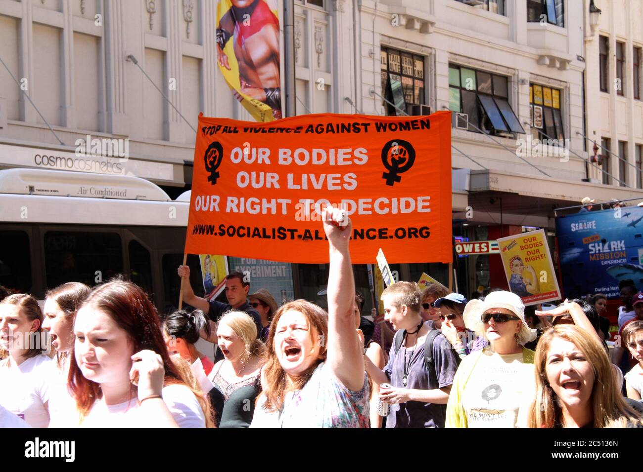 Protestierende marschieren entlang der George Street beim Internationalen Frauentag in Sydney. Ein Banner sagt: ‘Unsere Körper, unser Leben, unser Recht zu entscheiden’. Stockfoto