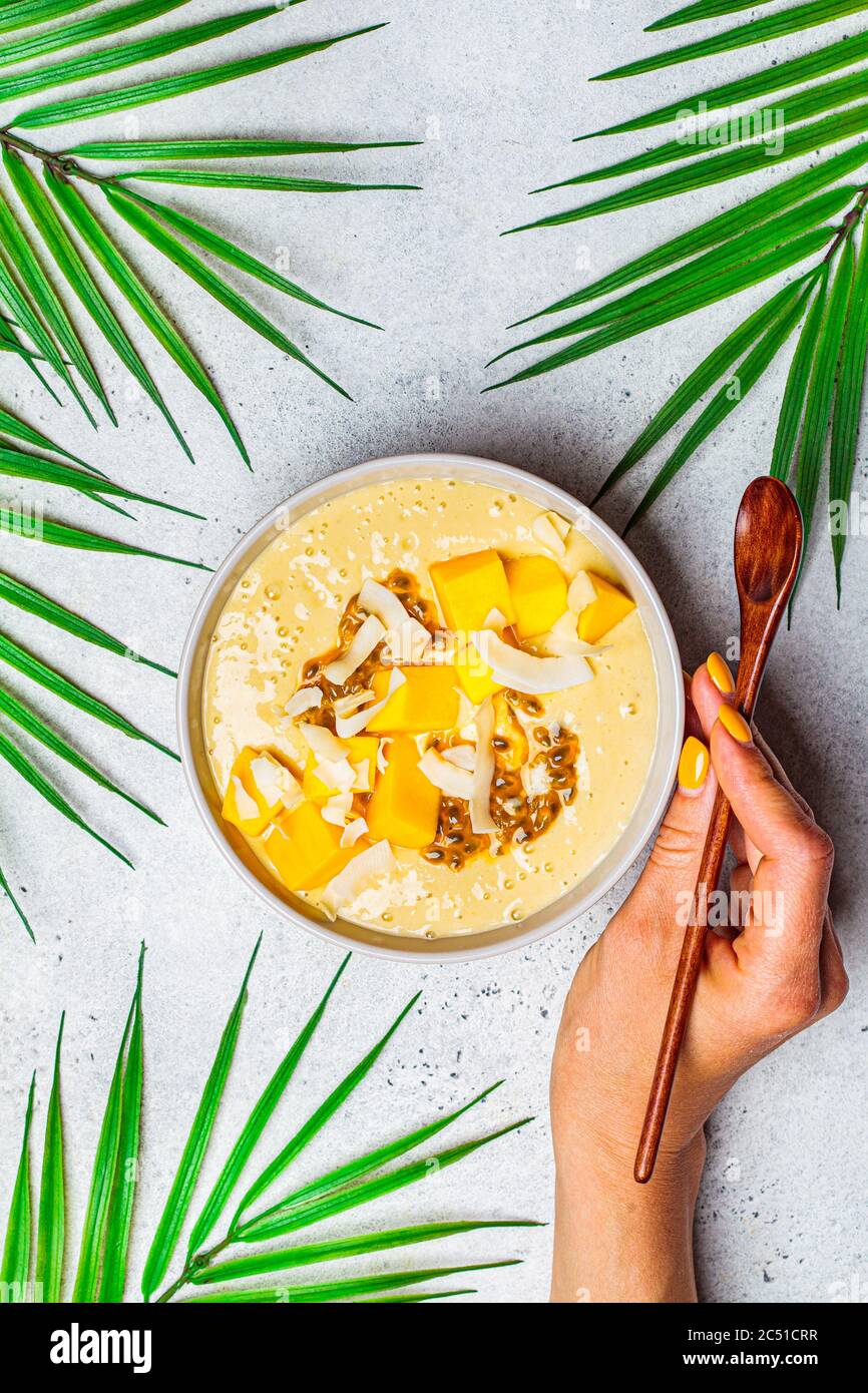 Tropische Mango und Kokosnuss Smoothie Schale, heller Hintergrund. Stockfoto