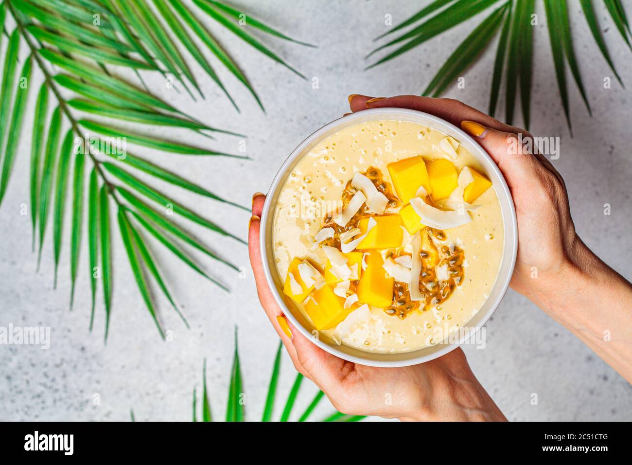 Tropische Mango und Kokosnuss Smoothie Schale, heller Hintergrund, Kopierraum. Stockfoto