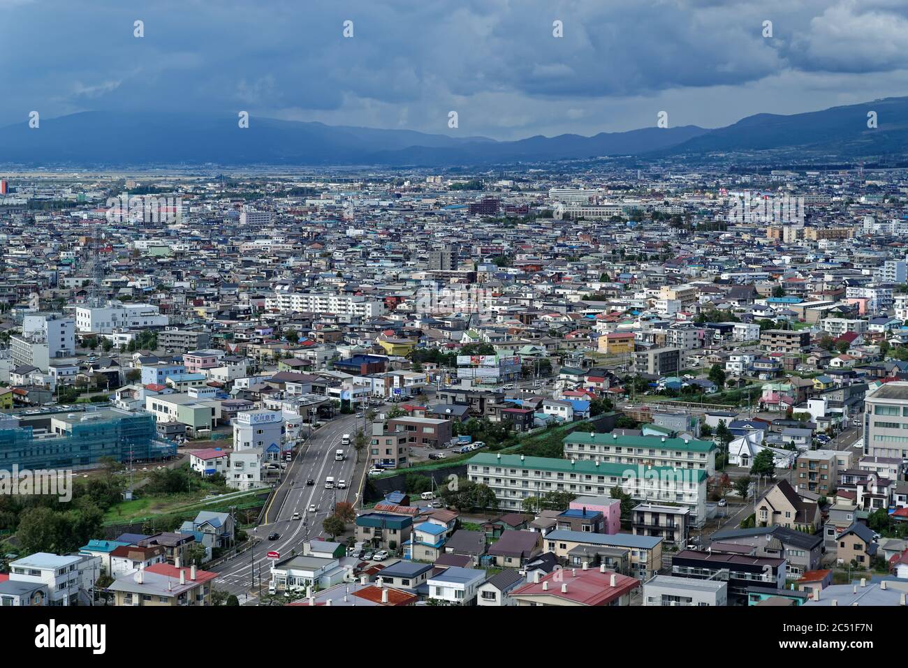 Tagesansicht der Vororte von Hakodate, im Norden Japans, sich in Richtung niedriger Hügel und Wolken in der Ferne ausdehnend Stockfoto