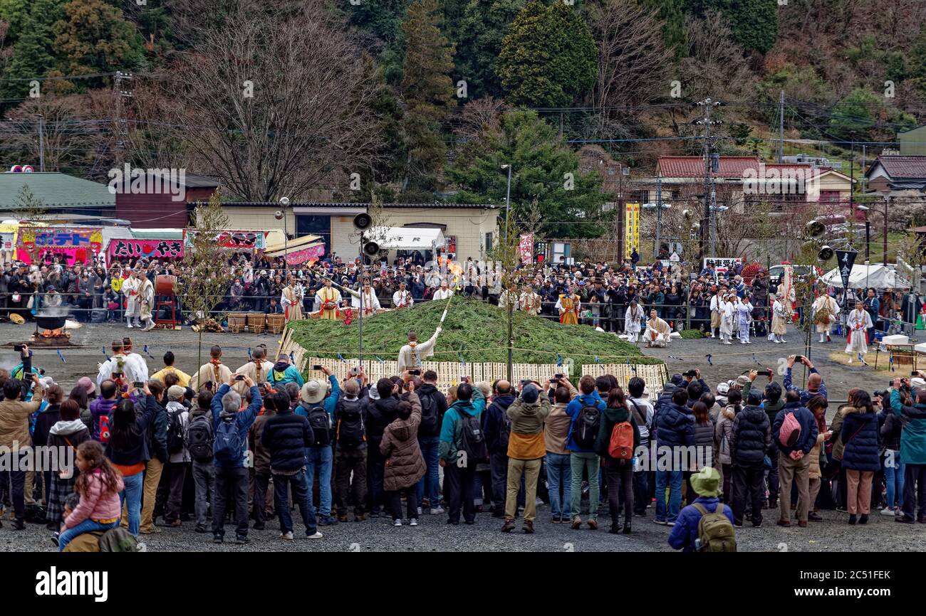 Eine große Menschenmenge beobachtet, wie Mönche Fackeln halten, um das zentrale Lagerfeuer beim jährlichen Feuer-Wanderfest nahe dem Berg Takao, westlich von Toky, anzuzünden Stockfoto
