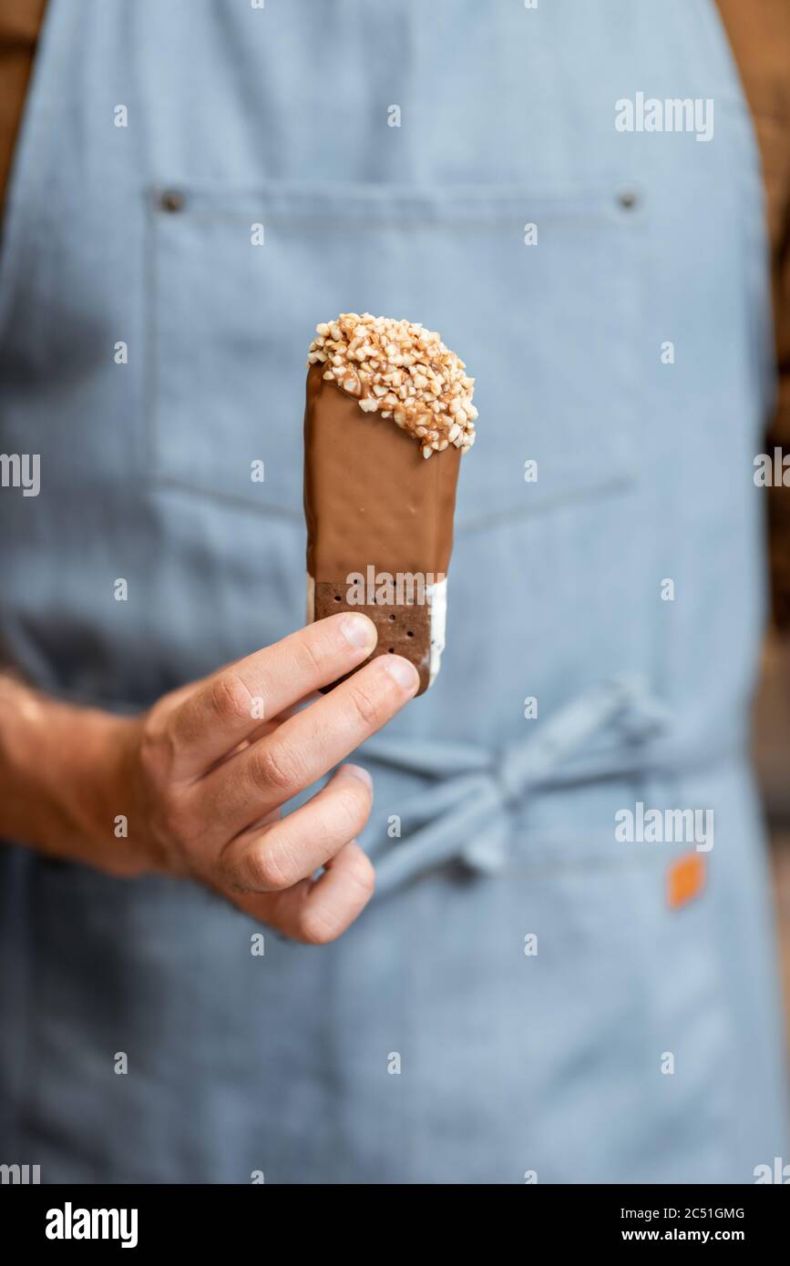 Verkäufer in Uniform halten Schokolade Eis, Nahaufnahme Stockfoto