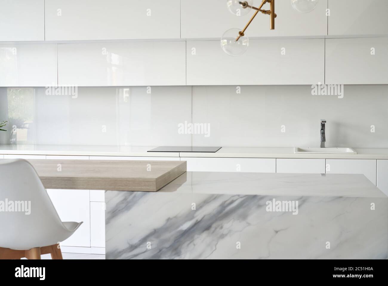 Küchentisch und verwackelte Hintergrund der glänzenden Küche Interieur. Minimalistischer oder skandaliger Stil. Stockfoto