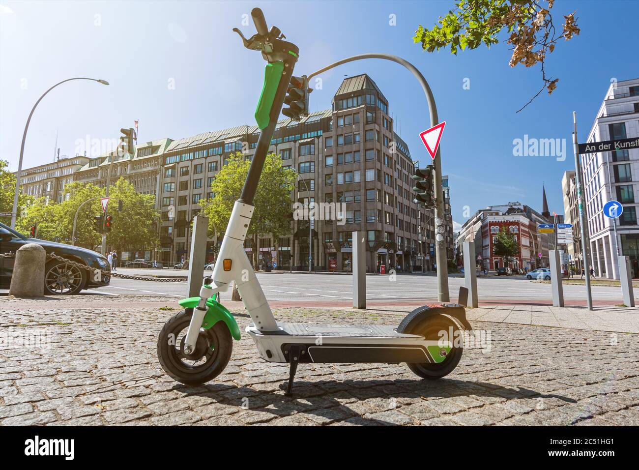 E-Scooter steht auf dem Bürgersteig in einer großen Stadt mit landschaftlich schönen Lichtreflexen Stockfoto