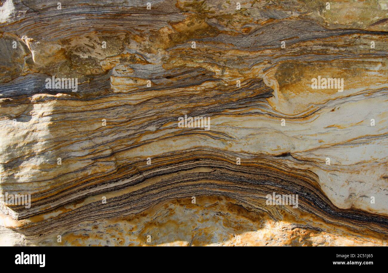 Die Schichten von Sedimentsandsteinen sind in diesen Jurassic Gesteinen an der Dinosaur Coast gut definiert. Die dunklen Partikel der Seekohle helfen abzubilden Stockfoto