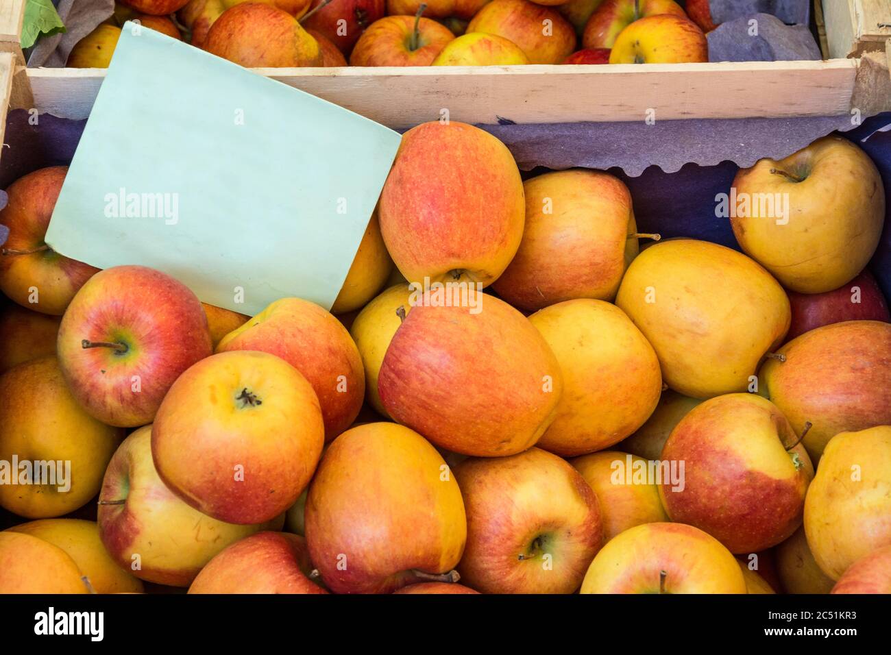 Frische Bio-Äpfel auf dem Bauernmarkt mit leerem Pappschild Stockfoto