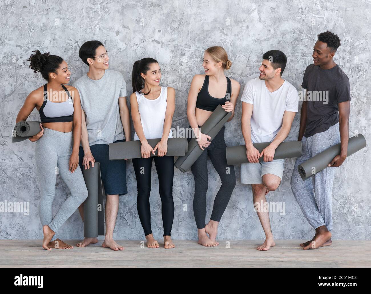 Gruppe von Menschen mit Yogamatten, die nach dem Unterricht im Fitnessstudio ruhen Stockfoto