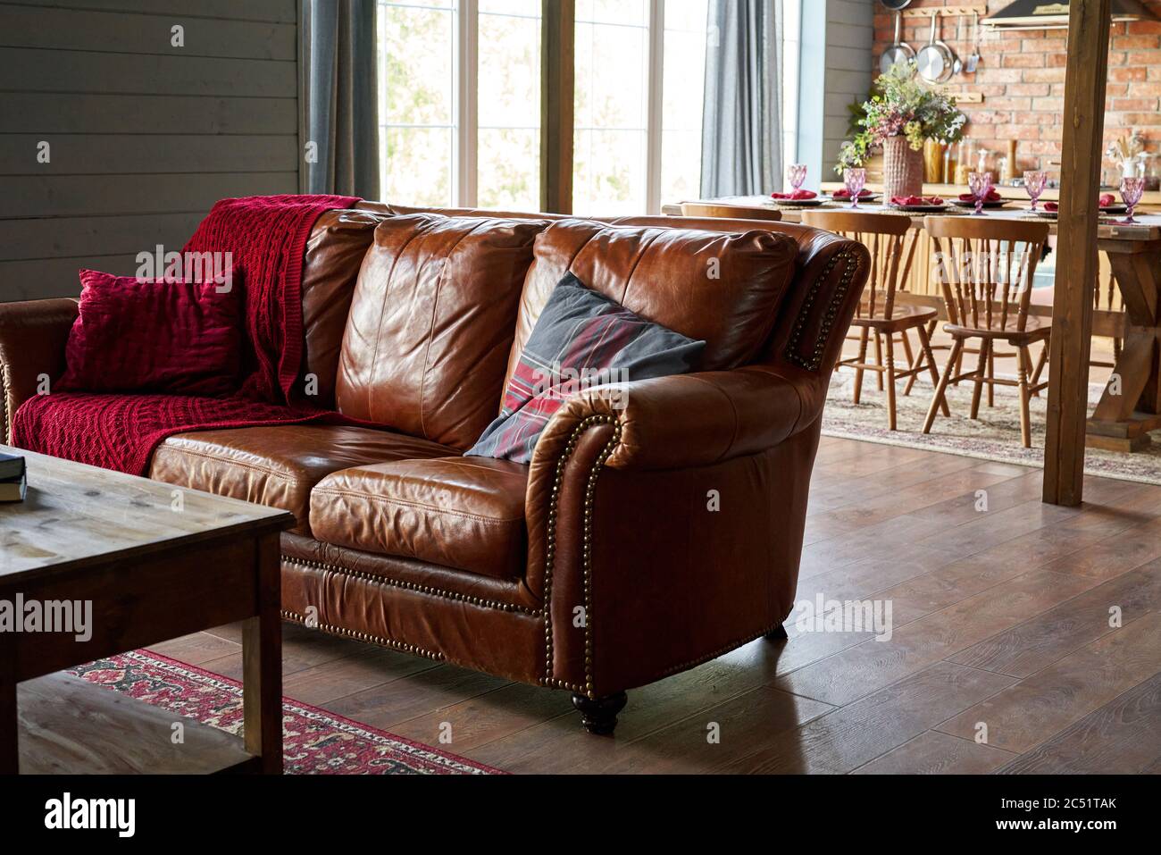 Gemütliches braunes Ledersofa mit Karloid in einem warmen Interieur Stockfoto