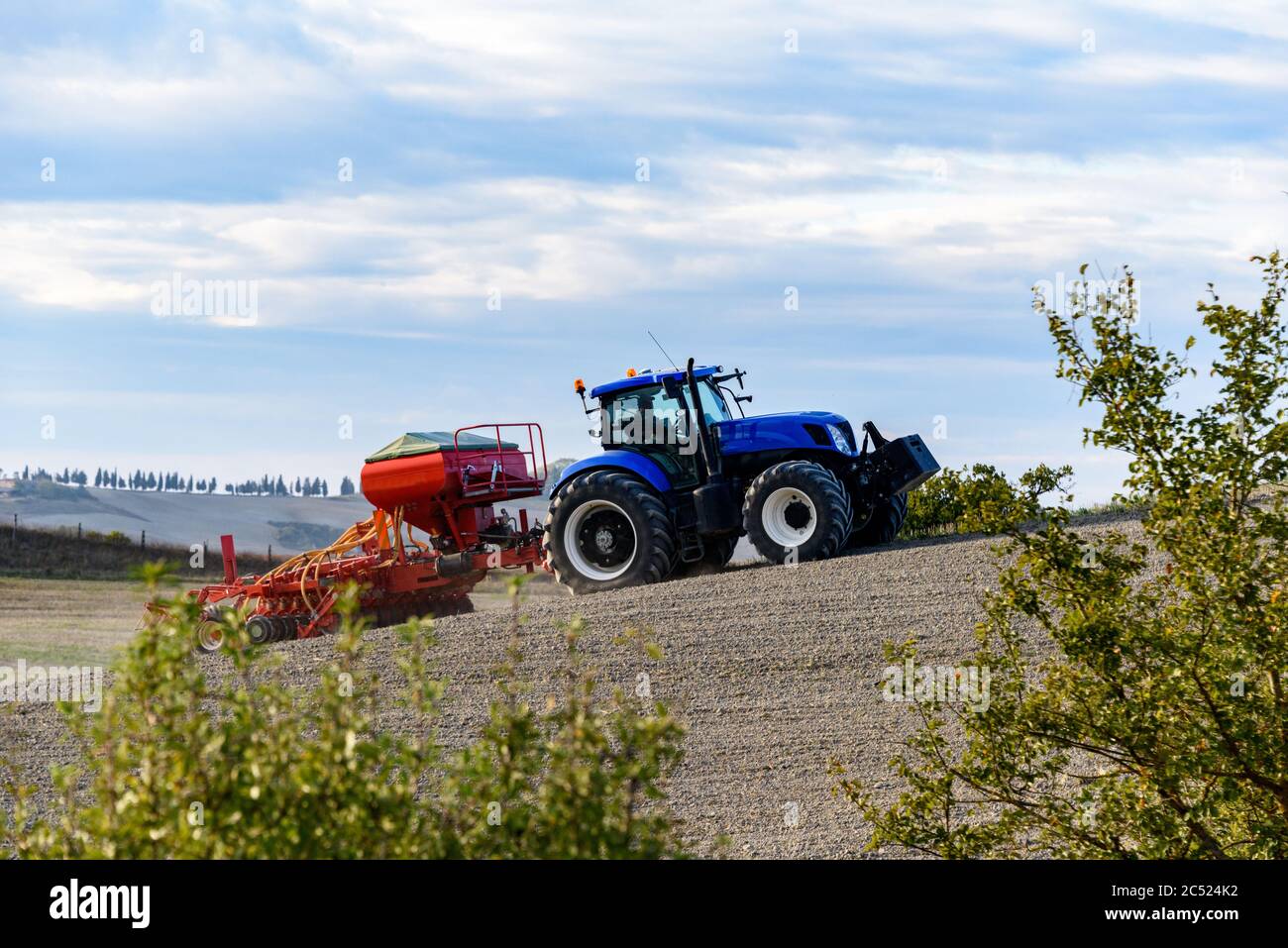 Ein Bauer in der Toskana bestellt sein Feld mit dem Traktor Stockfoto