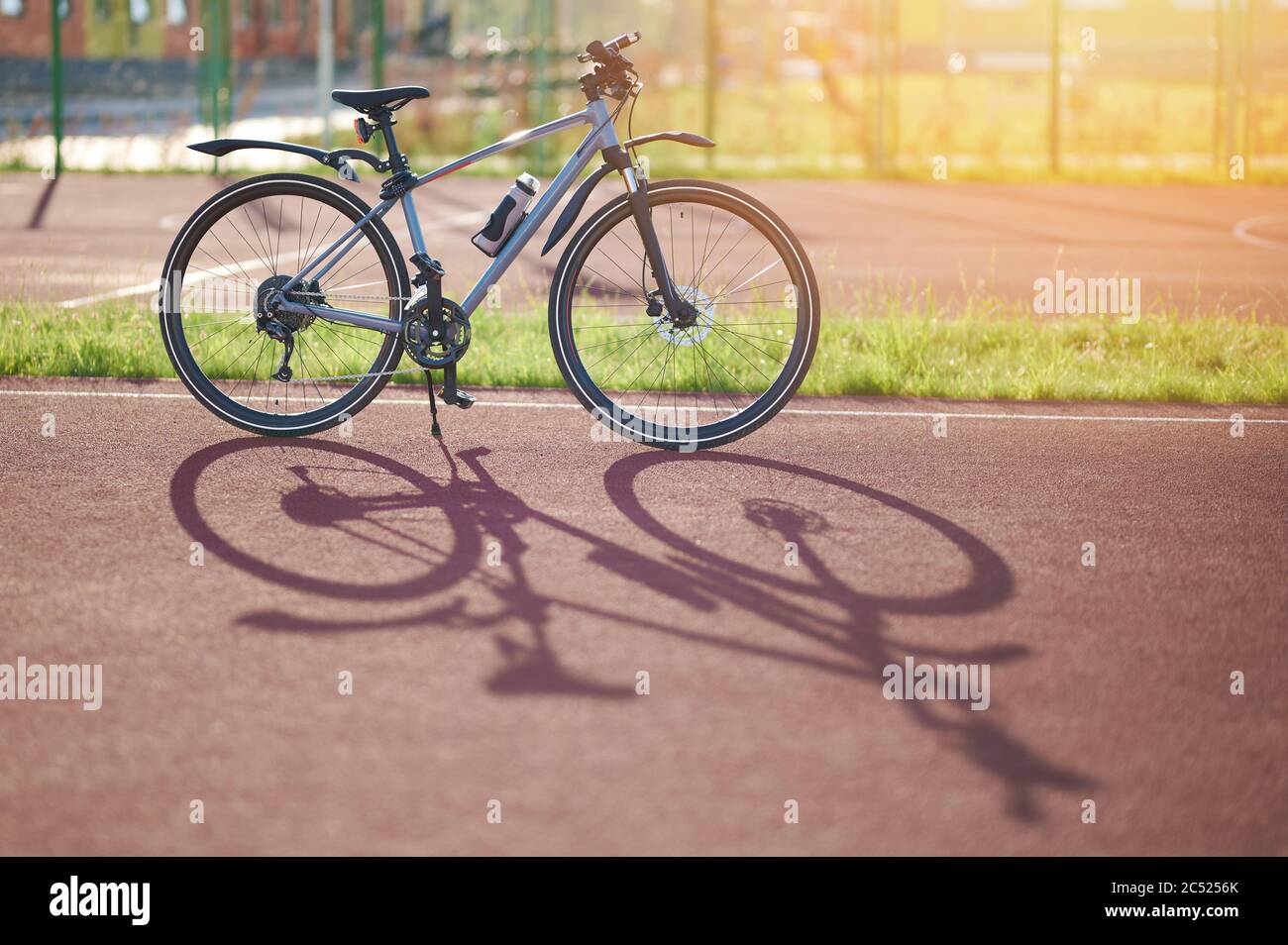 Thema Fahrradverleih. Blaues Fahrrad auf der Sportarena im sonnigen Licht Stockfoto