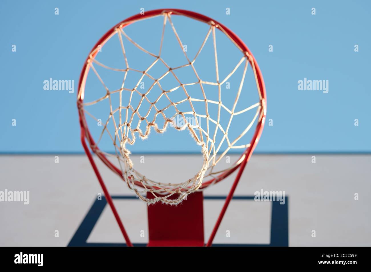 Basketball-Netz auf roten Ring unten Ansicht in blauen Himmel Hintergrund Stockfoto