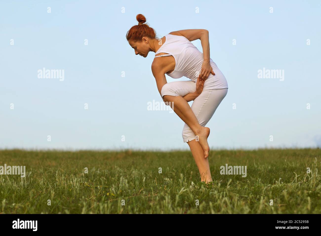 Ausgewogene junge Frau, die Yoga im Freien praktiziert Stockfoto