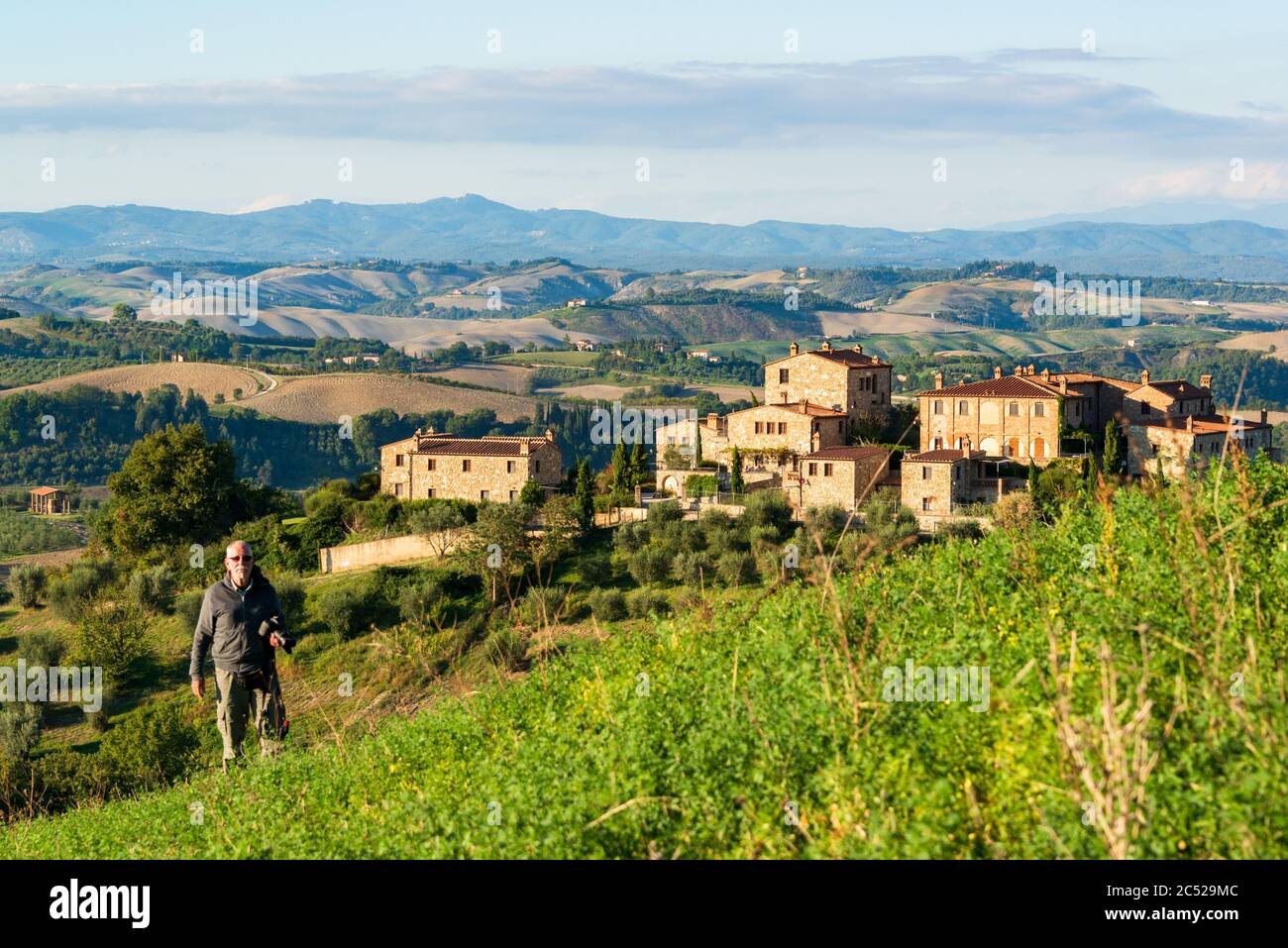 Wanderer in der Crete Senesi, einem Getreideanbaugebiet mit karstigen Abschnitten. Here is the Herbstuped Abendlicht Stockfoto