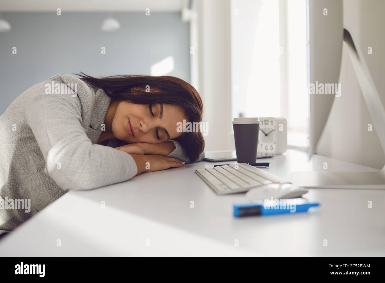 Müde Geschäftsfrau schläft am Arbeitsplatz im Büro ein. Stockfoto