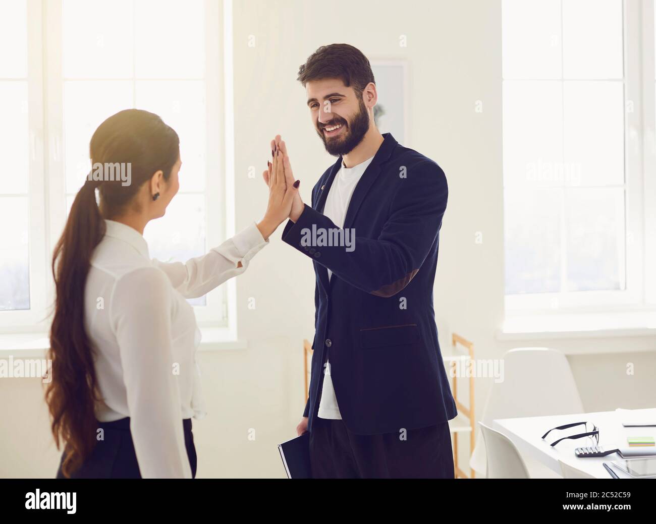 Geschäftsleute geben ein fünf Hände fröhliches Lächeln auf den Lippen, ein gelungenes Projekt am Arbeitsplatz in modernen Büros Stockfoto