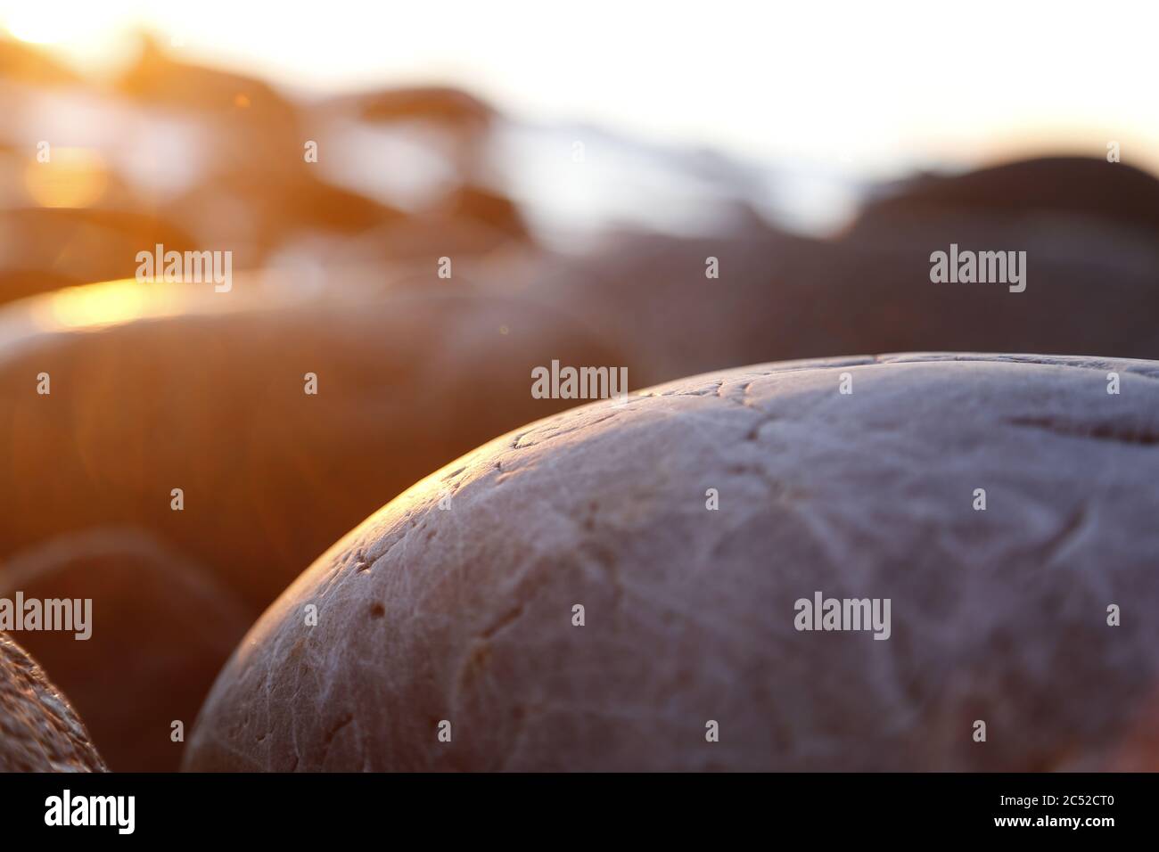 Steinige Strandsteine und Felsen, die abends in der Nähe beleuchtet sind, Sonnenuntergang und Sonnenaufgang Stockfoto