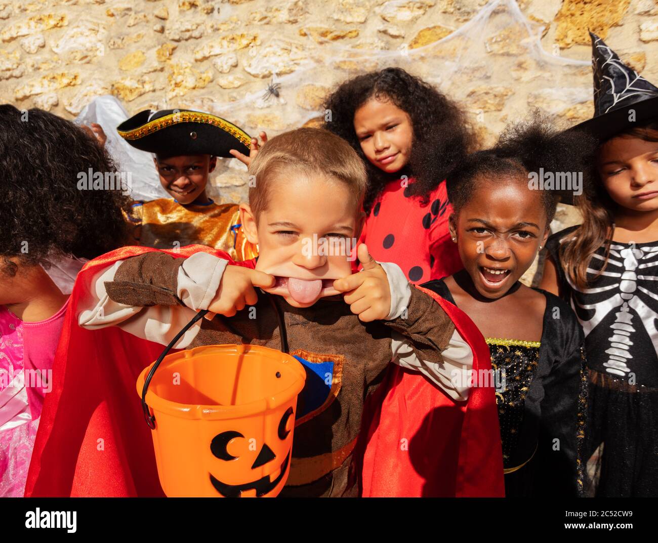 Portrait des kleinen Jungen ragt Zunge heraus und gestikuliert in Halloween Kostümen Stockfoto