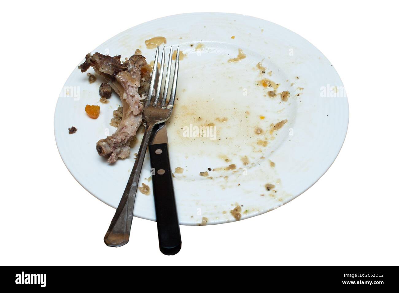 Schmutzige Platte mit Messer und Gabel mit Reste von übrig gebliebenen Speisen bereit zum Abwaschen auf einem isolierten weißen Hintergrund mit einem Schneideweg Stockfoto
